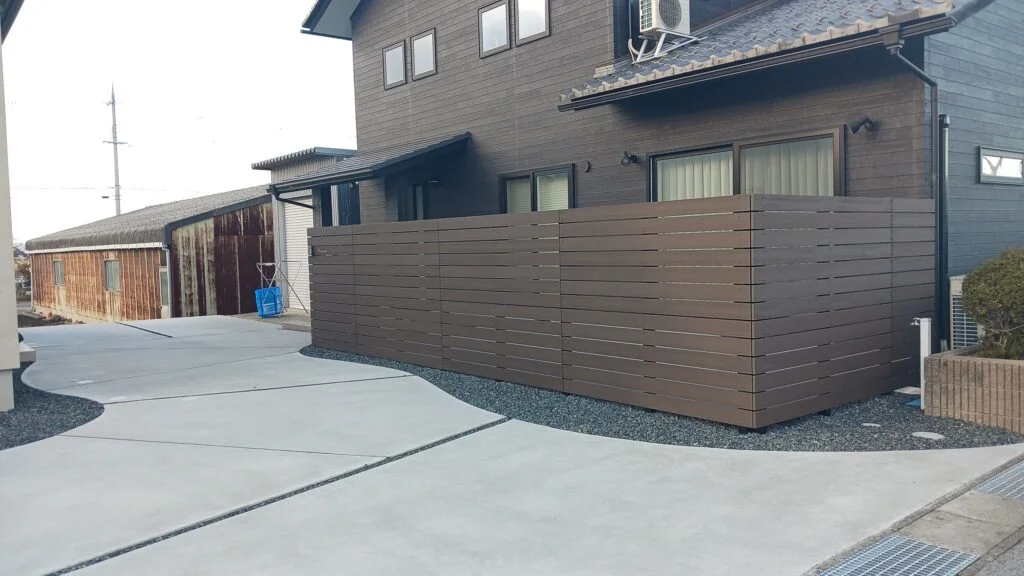 木調樹脂フェンスとコンクリートのシンプル外構