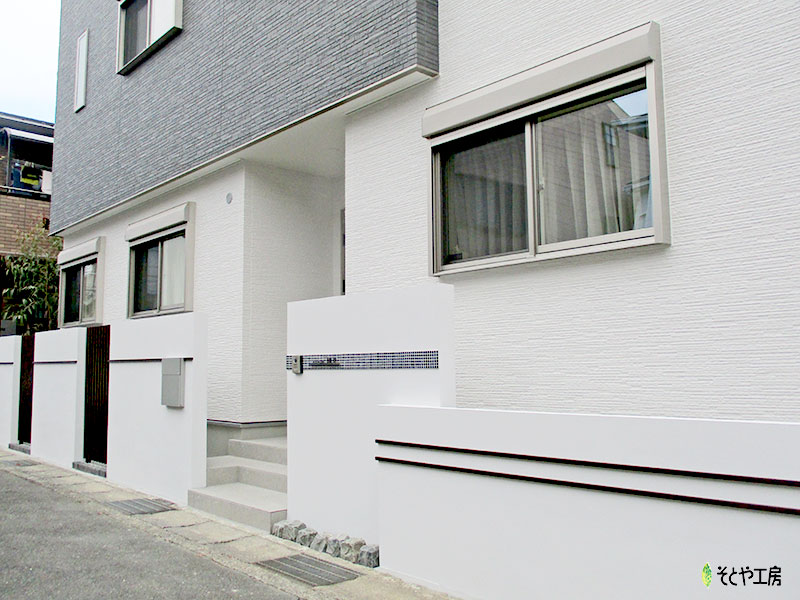 白い門壁に格子のアクセント